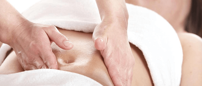 Mulher fazendo massagem de drenagem linfática na barriga